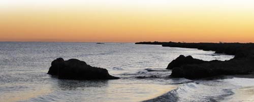 a view of the sea with sky orange in the evening