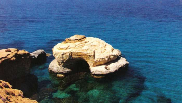 a view of a rock in the sea by the coast of alathrun