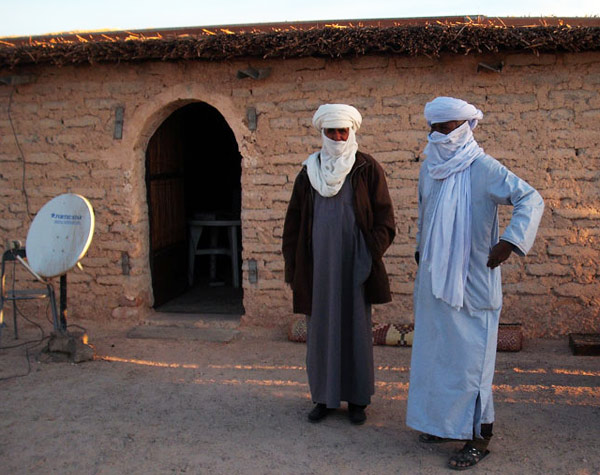 sahara desert guides standing near a satellite dish