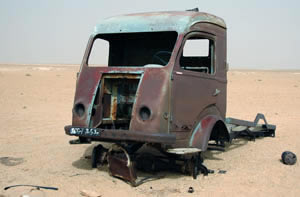 a rusty vehicle abandoned in the Hamada, sahara desert.