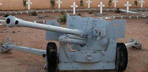 second world cannon before crossed graves in a cemetery in Tobruk