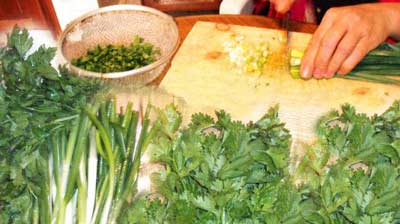 cutting the fresh herbs to be mixed with the mince