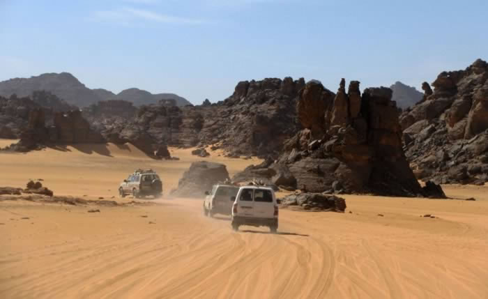 Acacus: desert cars entering an area of mountains