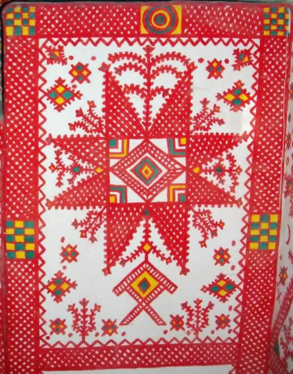 Ghadames interior wall  decorations in red over white walls.