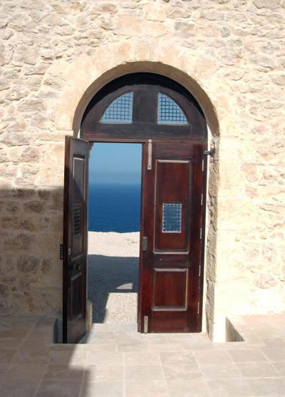 alburdi castle: a view of the sea from inside the building through the half open door.