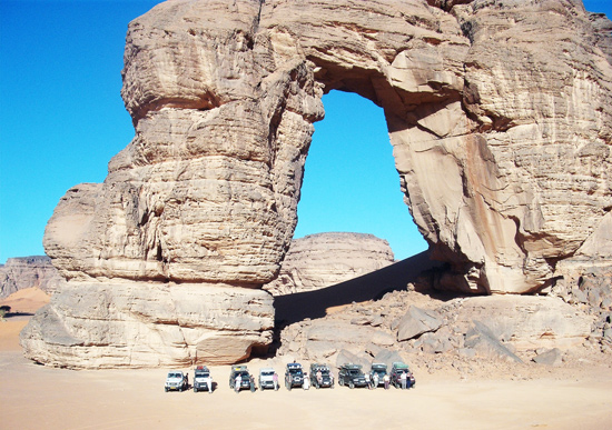 4x4 cars before the Big Arch of Afodzjar in Acacus